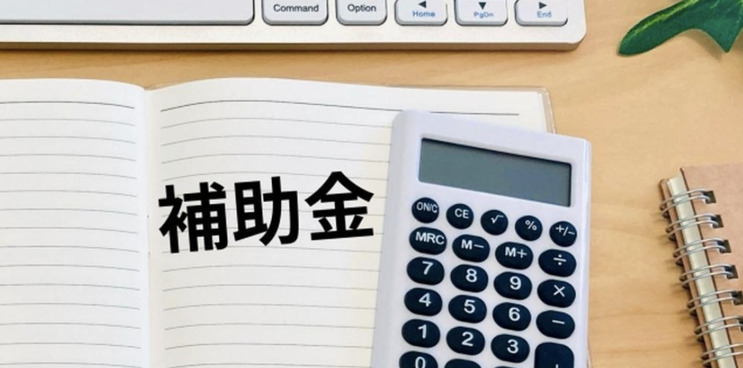 補助金の計算に関する資料と電卓が並ぶデスクのイメージ