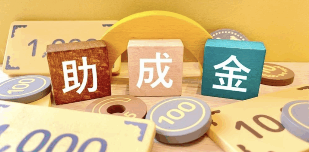 助成金の文字が書かれたカラフルな積み木と金額を模したパーツのイメージ