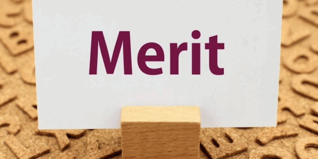 Meritと書かれたカードが木製スタンドに立てられているイメージ